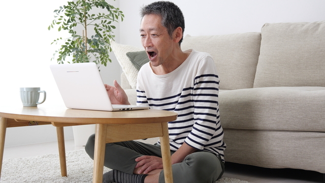 男性がパソコンを見ている写真